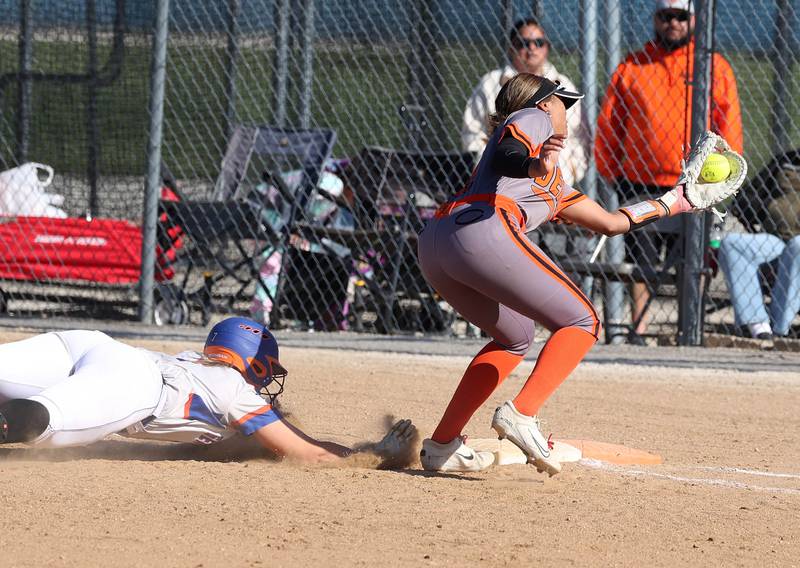 Genoa-Kingston's Elizabeth Davis dives back to first ahead of the tag of DeKalb's Alaynna Johnson Thursday, May 8, 2025, during their game at Genoa-Kingston High School.