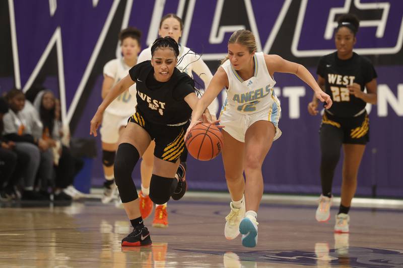 Joliet West’s Alaya Redditt and Joliet Catholic’s Sophia Mihelich run down the loose ball in the 2023 WJOL Girls Basketball Tournament on Friday, Nov. 17, 2023, in Joliet