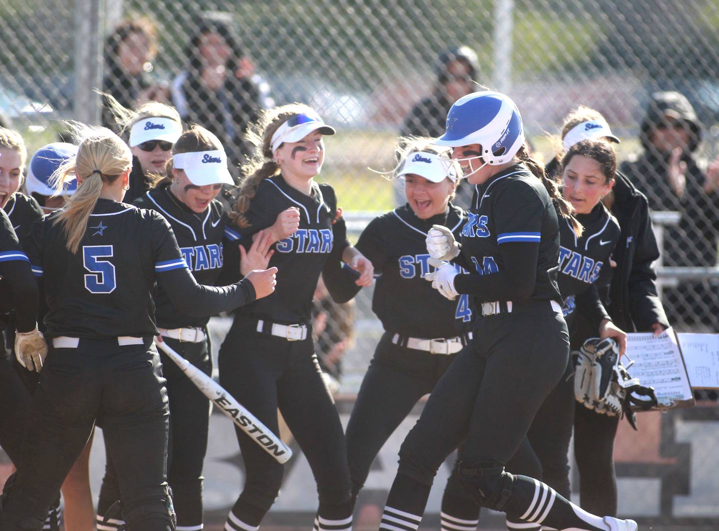 St. Charles North players celebrate teammate Abby Zawadzki’s homerun during a game at St. Charles East on Friday, April 19, 2024.