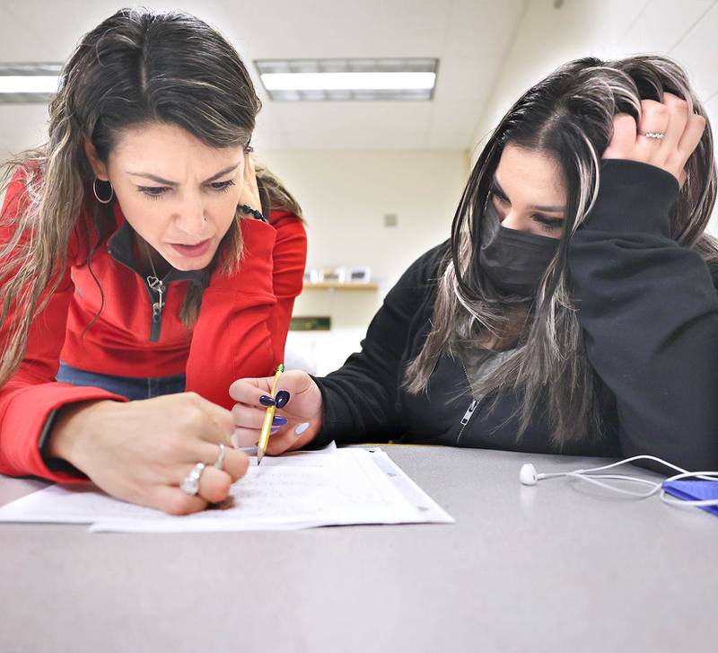 Claribel Robles, (left) director of the English Language Learners program for the Sycamore School District, helps freshman Shellyara Maymi Hinojosa with a math assignment during an ELL class Wednesday, April 6, 2022, at Sycamore High School.