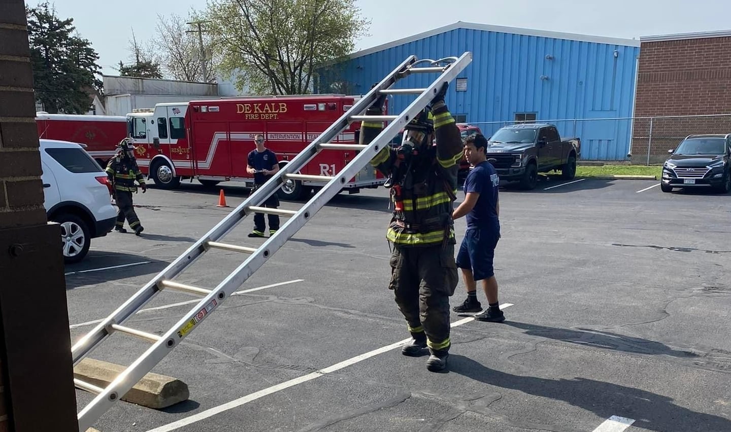 A DeKalb firefighter lifts a ladder as part of an obstacle course-like drill on Wednesday, April 17, 2024, at Station No. 1, 700 Pine St., DeKalb. The consumption drill is meant to help firefighters learn how quickly they'll go through a tank of oxygen during emergency response.