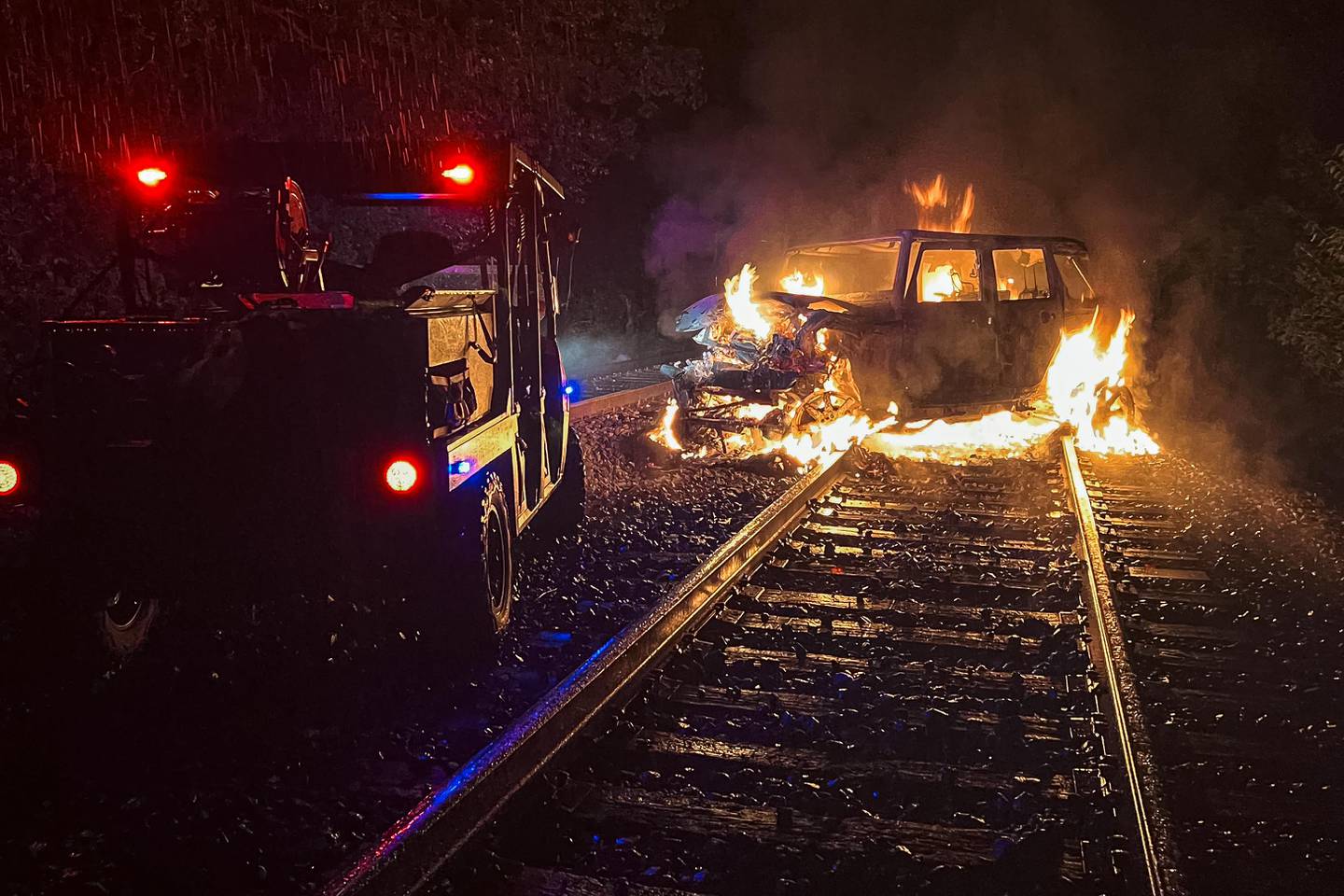 The Harvard Fire Protection District works a scene where a car was hit by a freight train and burst into flames early on Aug. 28, 2025. The driver was located about 20 feet away down a ravine.