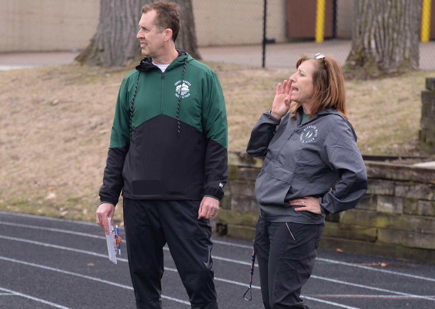 Glenbard West track and cross country coaches Paul and Kelly Hass give directions during practice Friday March 31, 2023.