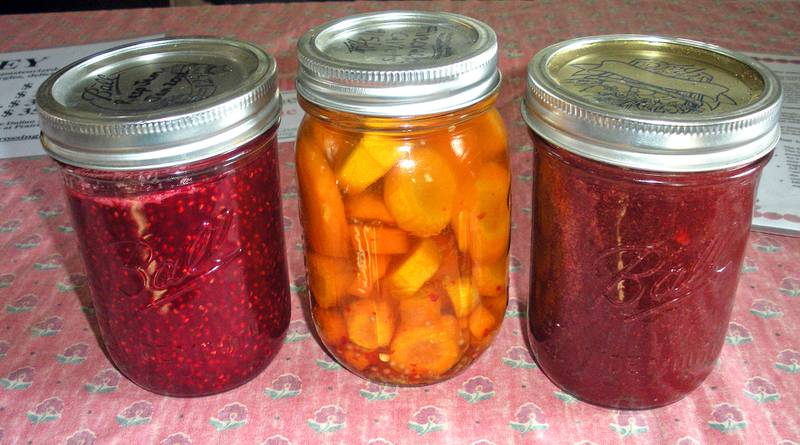 Becky Stark has canned food such as (from left) raspberry jam, made with her dad from raspberries in her parents’ backyard; pickled carrots; and strawberry sauce.