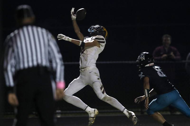 Richmond-Burton's Jace Nelson tries to make a one handed grab in front of Woodstock North's Michael Pintor during a Kishwaukee River Conference football game on Friday, Oct. 10, 2025, at Woodstock North High School.
