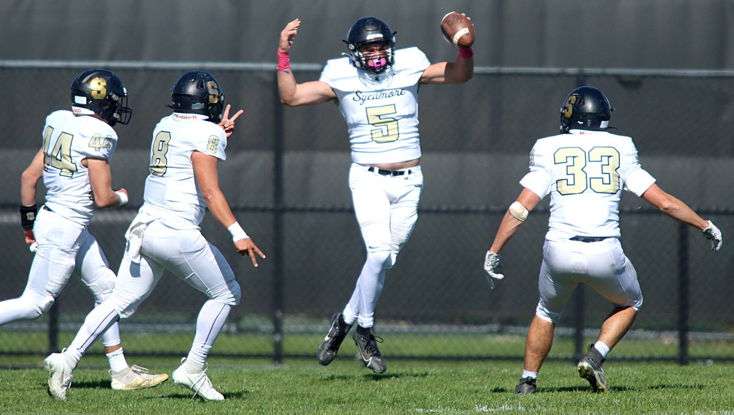 Sycamore’s Kyle Prebil (5) celebrates in the end zone after scoring a touchdown on an interception against Woodstock North in varsity football in Woodstock Saturday.