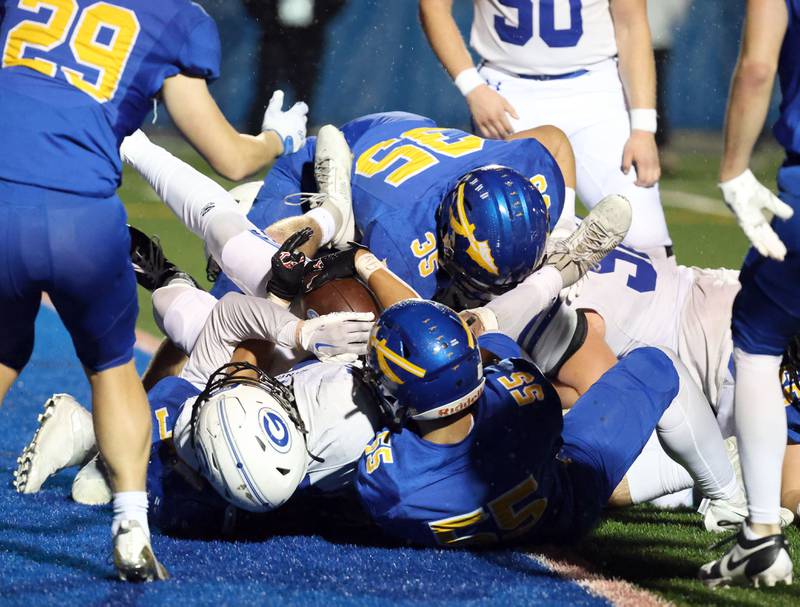 Geneva's Troy Velez (4) rolls in the end zone over a host of Lake Forest players for a touchdown during the IHSA Class 6A playoff game Friday November 3, 2023 in Lake Forest.