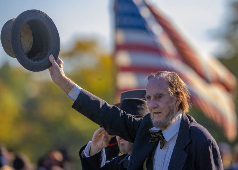 Abraham Lincoln, portrayed by Max Daniels raises his top hat to his soldiers after the battle at The Blue and Gray Civil War reenactment at City County Park on October 10, 2025 in Princeton.