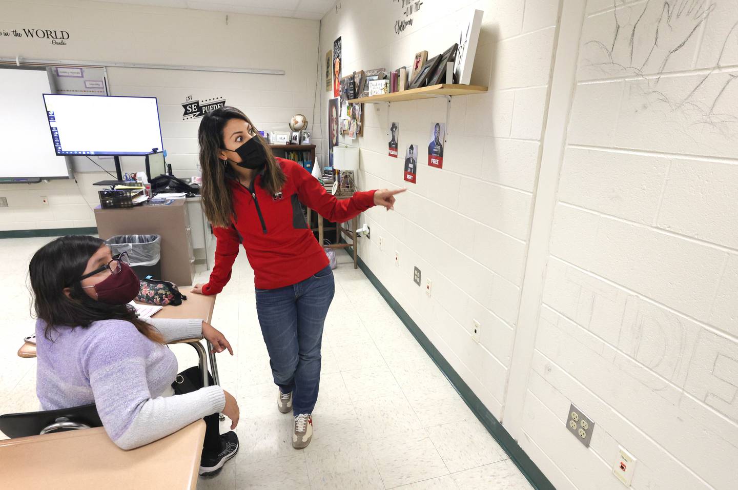 Claribel Robles, director of the English Language Learners program for the Sycamore School District, talks to Rocio Cuautle, a sophomore, about the mural Cuautle  is working on during an ELL class Wednesday, April 6, 2022, at Sycamore High School.