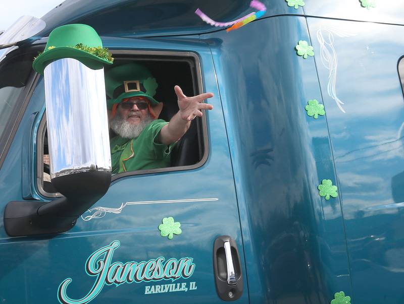 Roger Jameson throws beads out his truck window during the St. Patrick's Day parade on Saturday, March 16, 2024 downtown Utica.