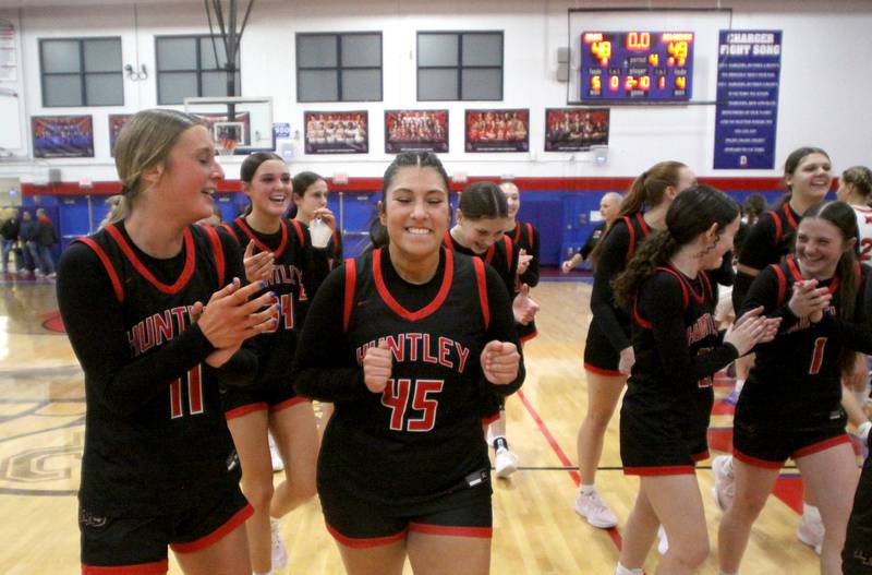 Huntley’s Red Raiders celebrate a win over Maine South in Komaromy Holiday Classic varsity girls basketball championship game action on Monday, Dec. 30, 2024, at Dundee-Crown High School in Carpentersville. Anna Campanelli is at left and Madison Diaz is in the center.