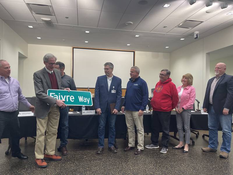 DeKalb City Manager Bill Nicklas presents  Seventh Ward Alderman Tony Faivre with an honorary street sign, shown during the April 24, 2023 meeting of the DeKalb City Council.