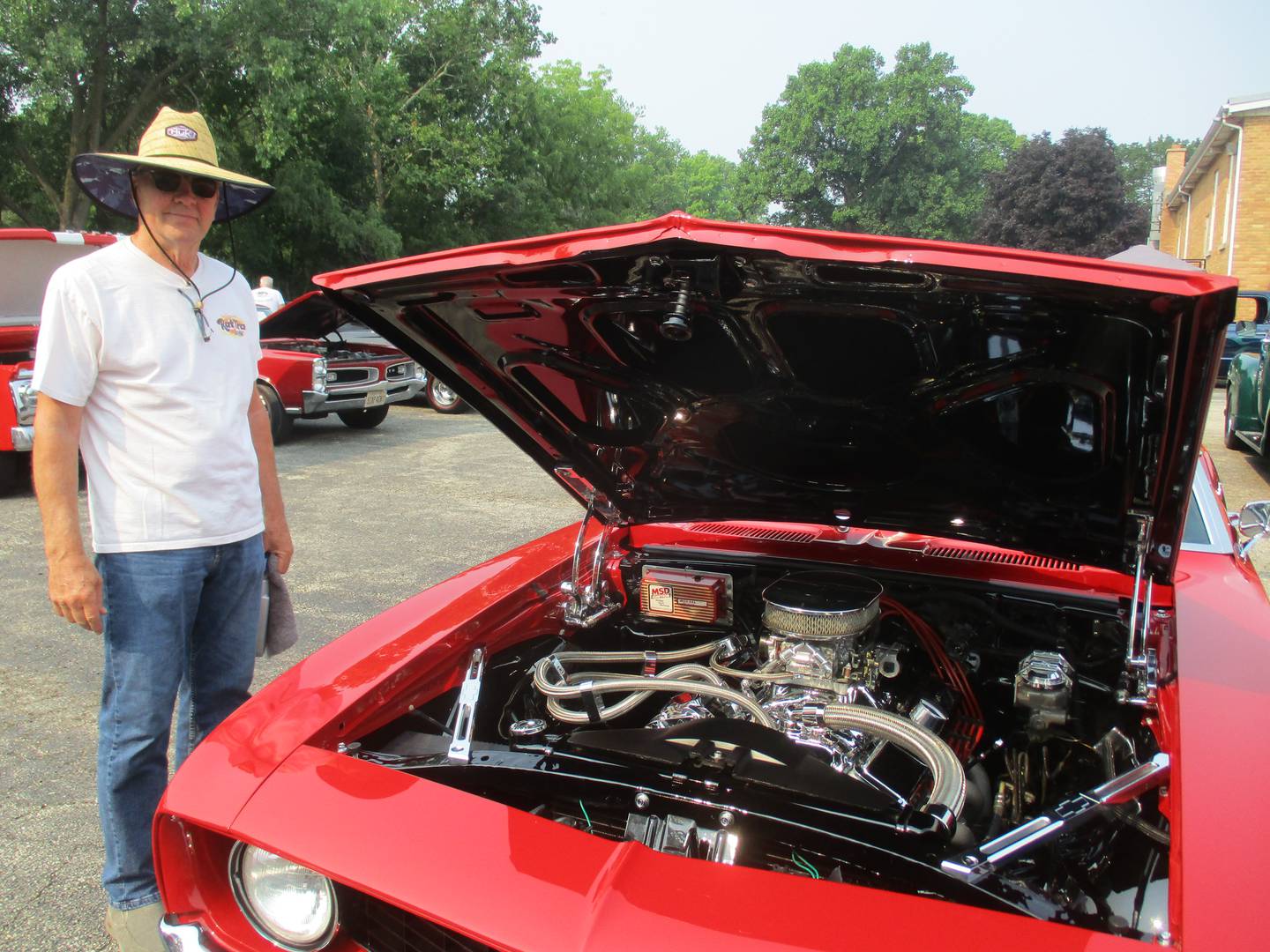 Joe Hollmier of Sugar Grove reveals the spotless engine for his 1969 Chevrolet Camaro at the Plano American Legion Post 395 car show on July 16, 2023.