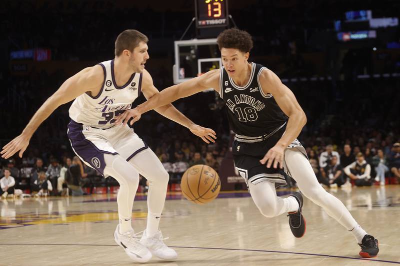 San Antonio Spurs forward Isaiah Roby (18) drives past Los Angeles Lakers forward Matt Ryan (37) during the second half of their NBA game Sunday, Nov. 20, 2022 in Los Angeles.