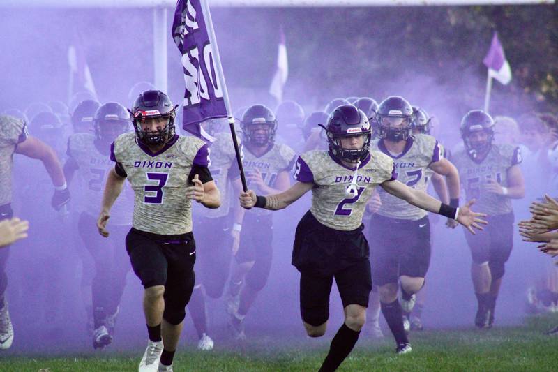Dixon Rylan Ramsdell (3) and Jath St. Pier (2) lead Dixon out onto the field for its home opener against Rockford Christian.