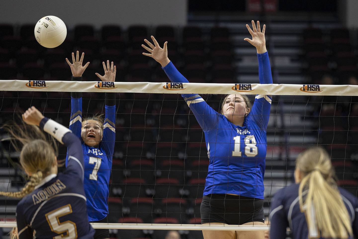 Newman’s Makenzie Duhon (left) and Kennedy Rowzee go up to block a shot Friday, Nov. 11, 2022 in a class 1A volleyball semifinal against Aquin.