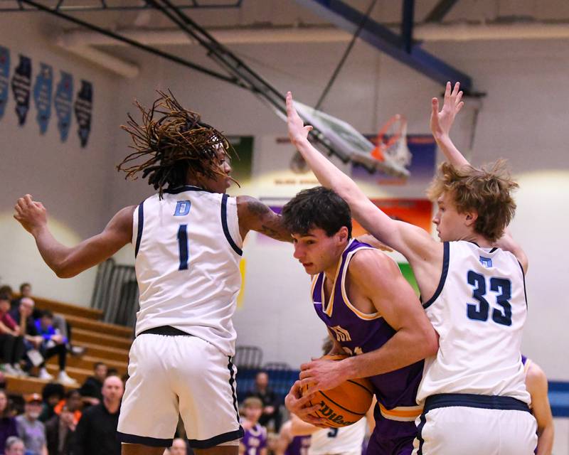 Downers Grove North's Aidan Akkawi (24) gets a shot off after squeezes through Downers Grove South defenders Keon Maggitt (1) and Erik Vagonis (33) during the game on Saturday Dec. 21, 2024, held at Downers Grove South High School.