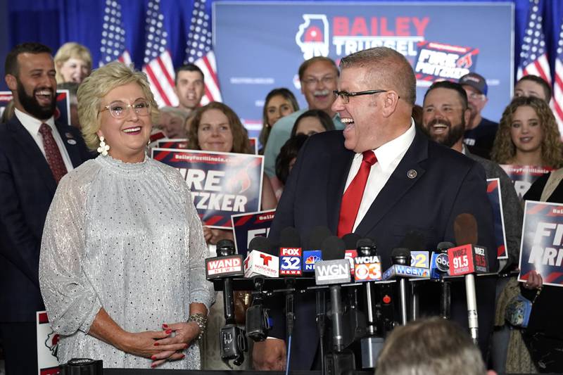 Republican gubernatorial candidate Darren Bailey, right, laughs with his wife Cindy Stortzum while responding to reporters questions after winning the Republican primary Tuesday, June 28, 2022, in Effingham, Ill. Bailey will now face Democratic Gov. J.B. Pritzker in the fall. (AP Photo/Charles Rex Arbogast)