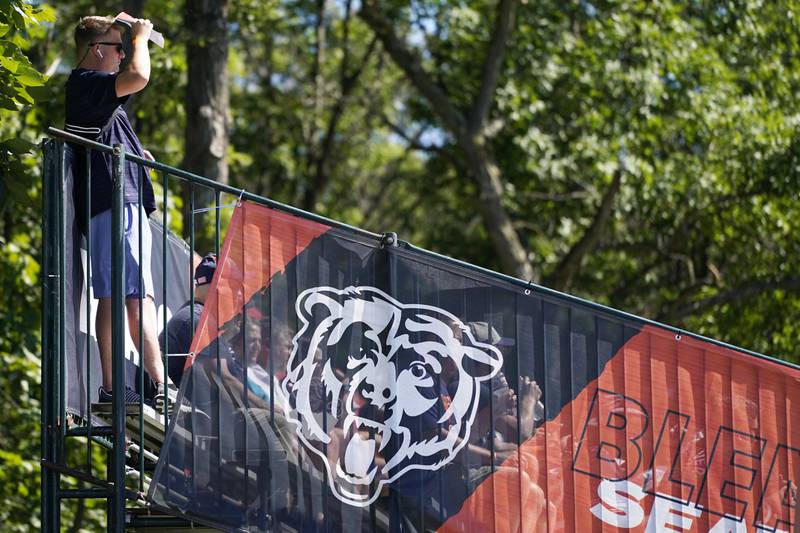 A fan watches Chicago Bears players at the team's practice facility, Friday, July 29, 2022, in Lake Forest.