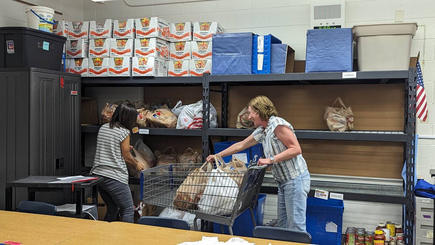 Bags of Hope board members Allison Suchinski (left) and Nancy Crouch (right) fill a grocery cart with food on Wednesday, October 4, 2023, at Plainfield Academy. Bags of Hope is a Plainfield-based nonprofit that feeds hundreds of Will County students each weekend through a donation-funded backpack program.