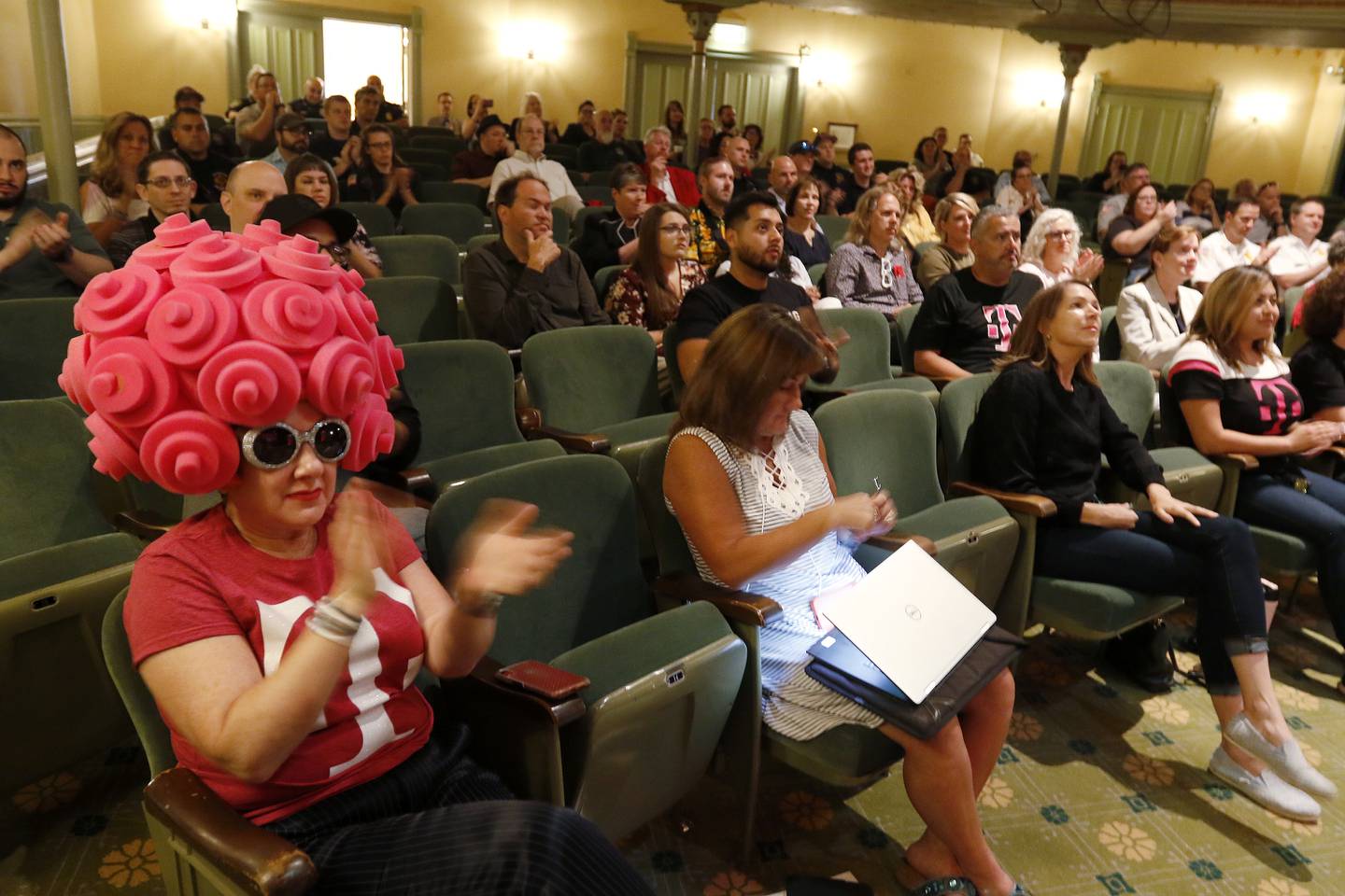 Audience members, including Jodie Kurtz-Osborne of Woodstock, left, applaud inside the Woodstock Opera House as Danielle Gulli announces the city's standing among the top ten finalists in a $3 million grant from T-Mobile on Thursday, July 15, 2021 in Woodstock.