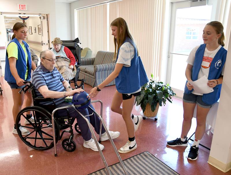 L-P girls basketball players Kendall Bassett (from left), April Pescetto, and Ella McCauley help Fred Leone, a Veterans Home resident, line up his shot during a bowling activity Thursday afternoon in the Veterans Home in LaSalleon Thursday, July 27, 2023 at the Illinois Veterans Home in La Salle.
