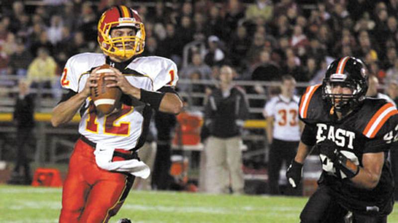 Batavia quarterback Noel Gaspari gets chased by St. Charles East's Joe Hoscheit during Friday's game.