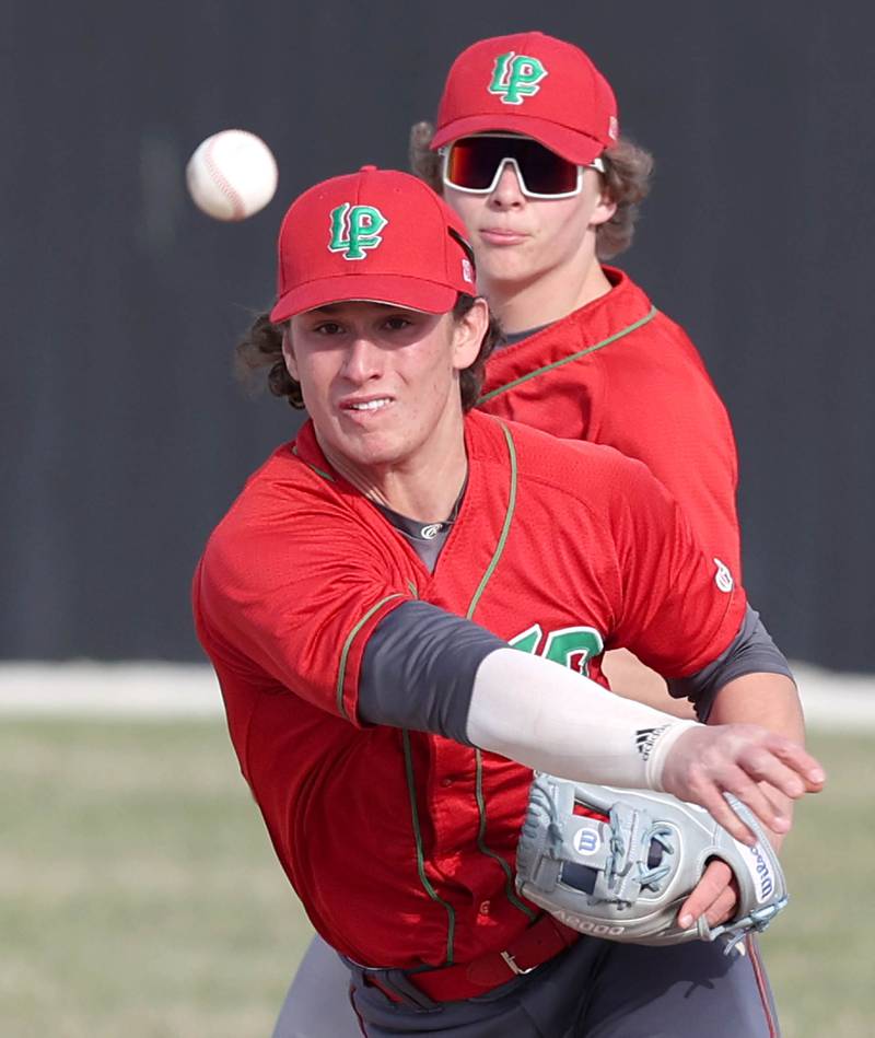 LaSalle-Peru's Jack Scheri throws the ball to first as teammate Mason Lynch looks on during their game against Sycamore Monday, April 11, 2022, at the Sycamore Community Sports Complex.