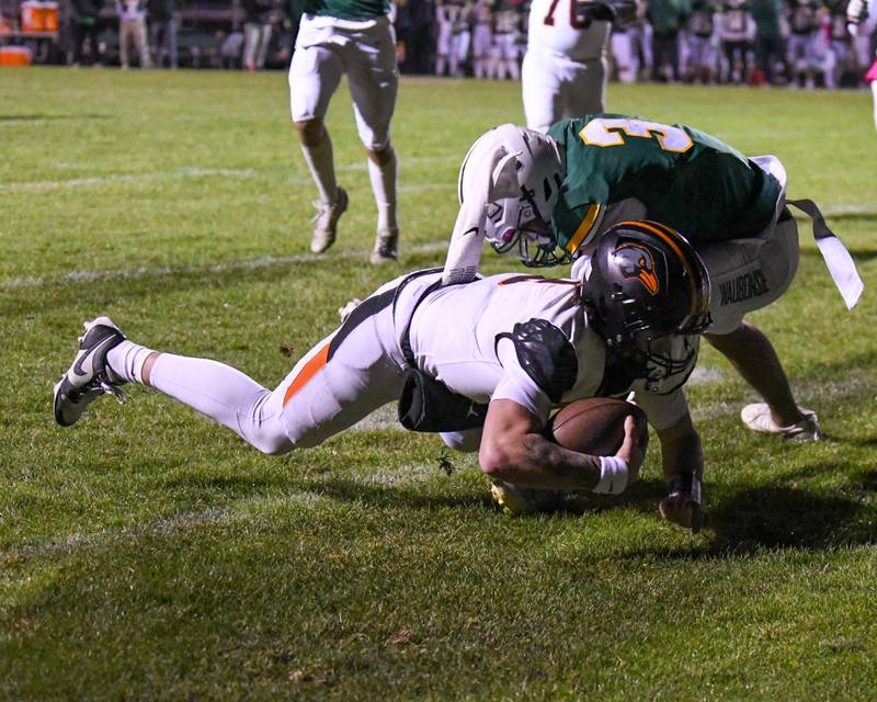 DeKalb's Cole Latimer (2) crosses the goal line for a touchdown while being defended by Waubonsie Valley's Josiah Griffin (3) during the game on Friday Oct. 24, 2025, held at Waubonsie Valley High School.