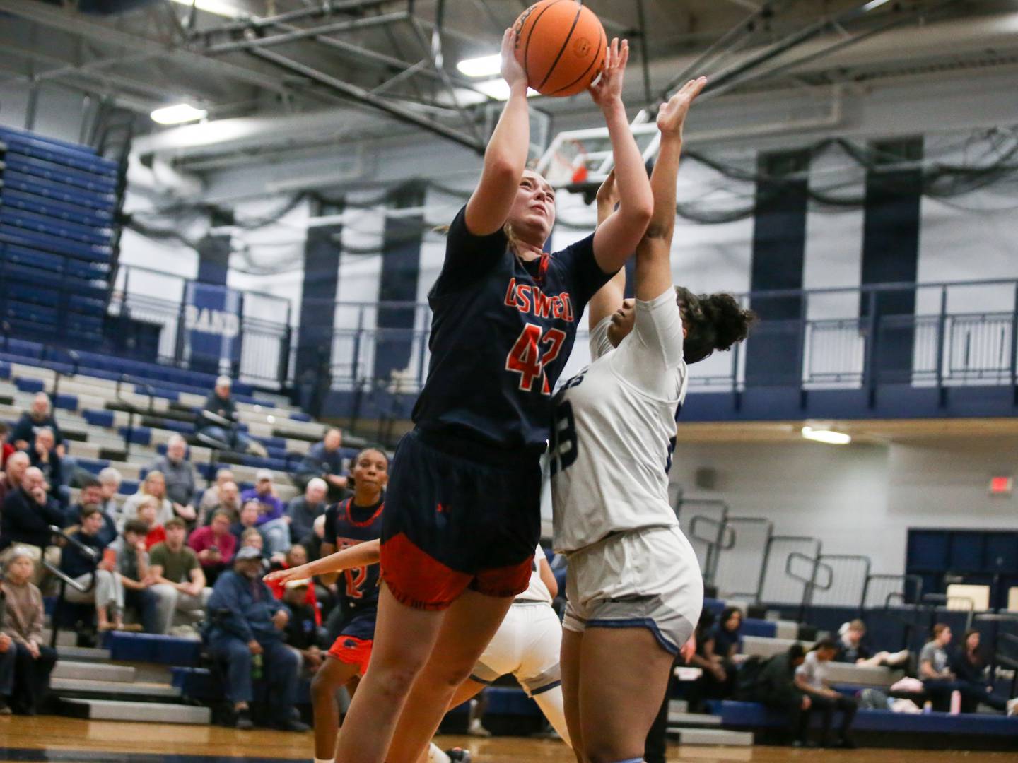Oswego's Kendall Grant (42) shoots over Oswego East's Inspire Fisher (23) during their basketball game between Oswego at Oswego East, Feb 10, 2026 in Oswego.