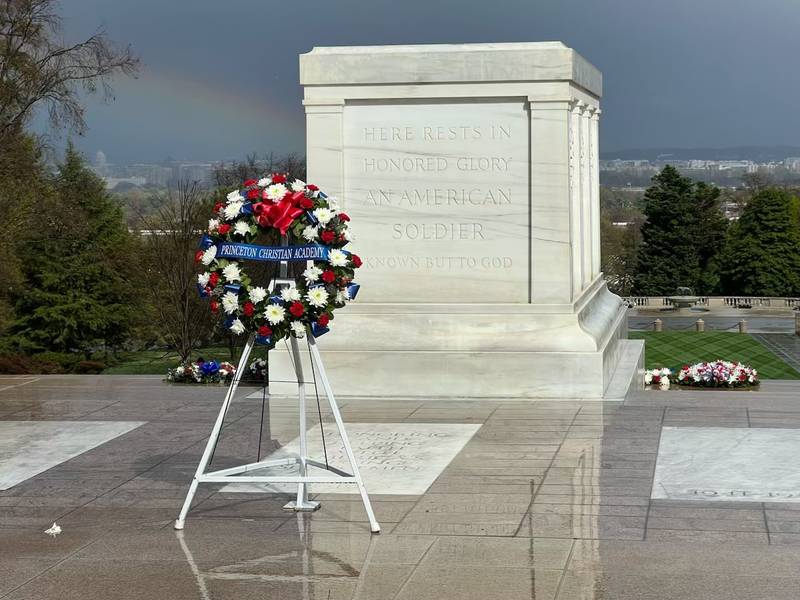 A rainbow forms in the background on a rainy day during Princeton Christian Academy's wreath laying ceremony at the Tomb of the Unknown Soldier at Arlington National Cemetery on Thursday.