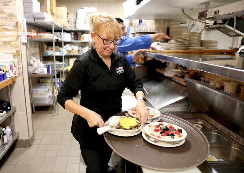 Server and manager Darlice Augustine loads up her tray with breakfast items, including egg skillets, at Briana’s Pancake House in Batavia on Thursday, Jan. 19, 2023.