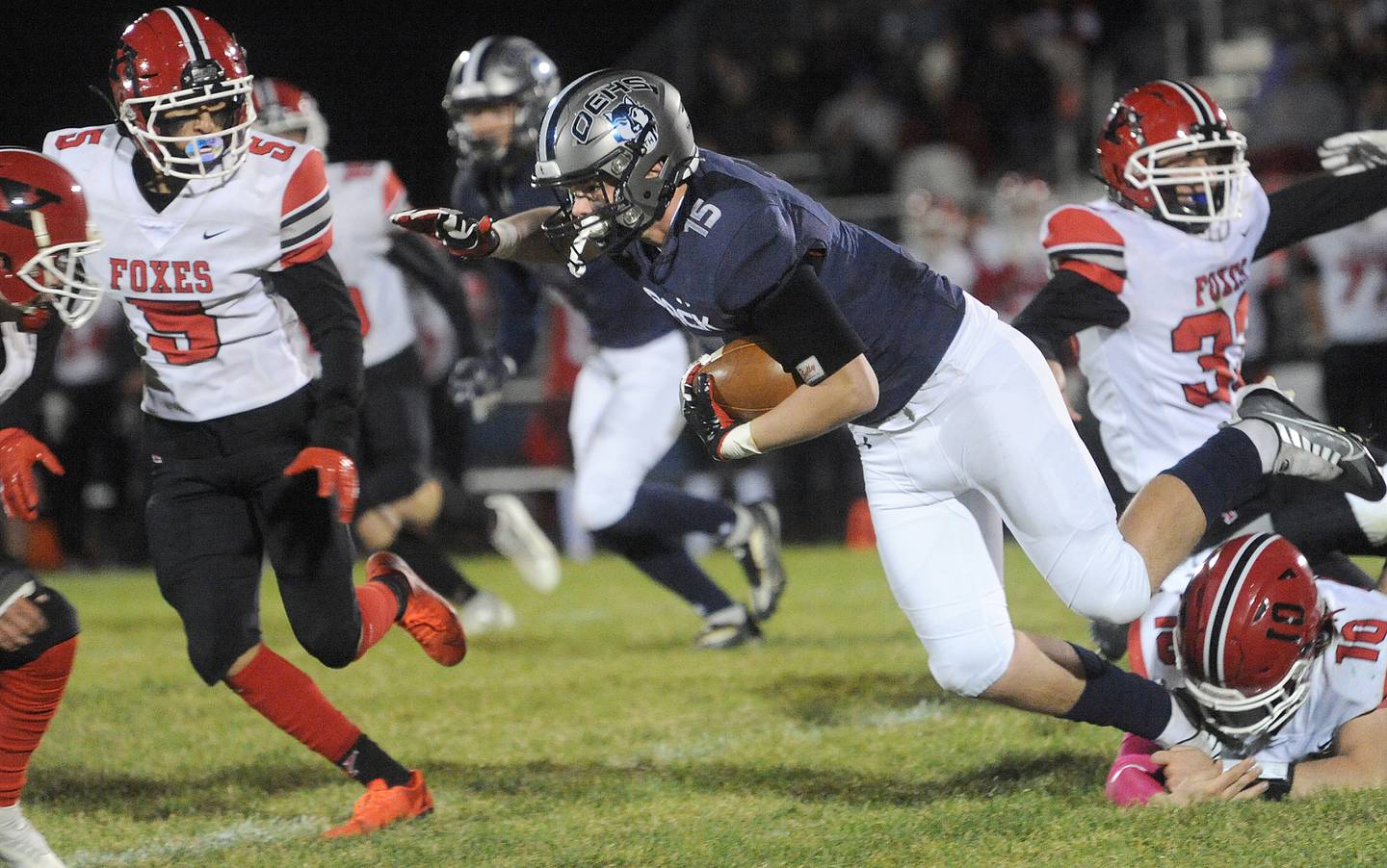 Oswego East running back Aiden Moriarty (15) finds space between Yorkville defenders during a varsity football game at Oswego East High School on Friday, Oct. 7, 2022.