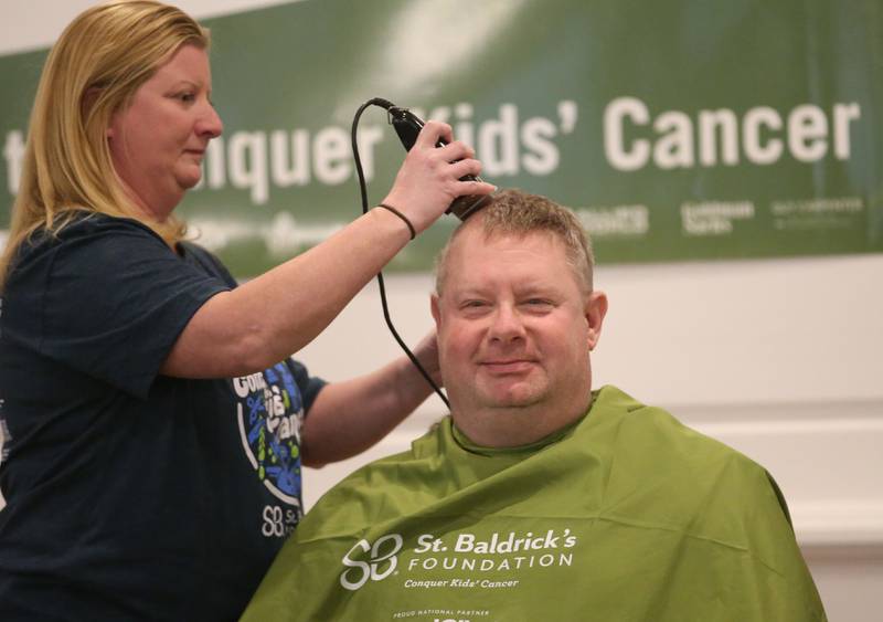 Mike Porter vice president of Eureka Saving Bank, has his head shaved by beautician Sarah Stewart of Downstairs on 1st Day Spa during the 18th annual Illinois Valley Emergency Services St. Baldrick's event on Sunday, March 23, 2025 at Senicas Oak Ridge in La Salle.