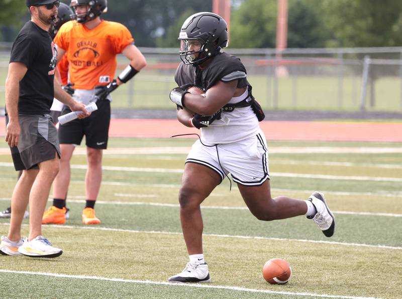 DeKalb’s Travis Moore carries the ball Wednesday, July 15, 2025, during a summer practice session at the school.