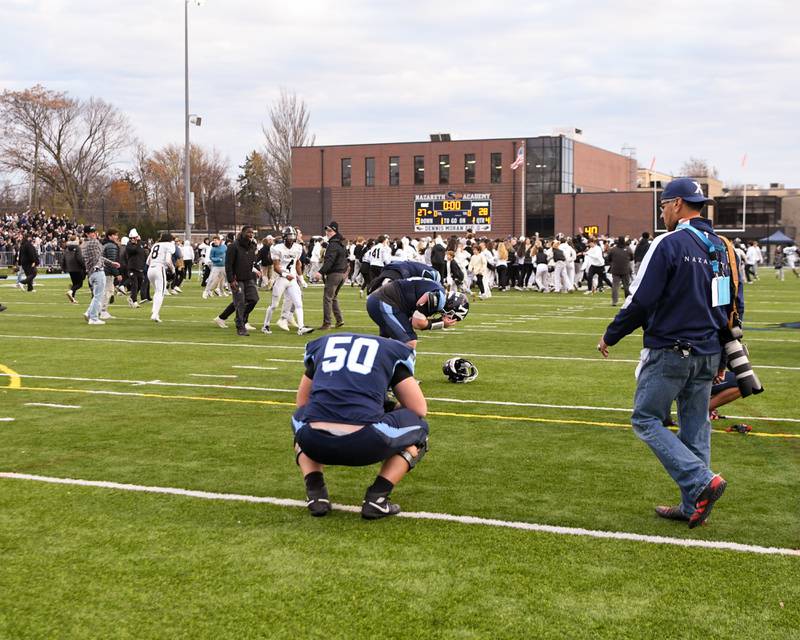 Fenwick fans storm the field at Nazareth Academy High School in La Grange Park as the football team stopped Nazareth Academy from making a two-point conversion during the 6A semifinals game in overtime on Saturday Nov. 22, 2025, held at Nazareth Academy High School in La Grange Park.