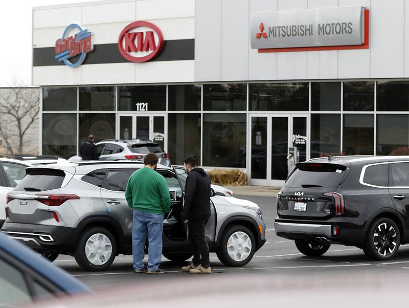 Customers looks at a Kia for sale on Thursday, Dec. 8, 2022, at Castle AutoPlex, 1107 Route 31 in McHenry. Castle, which purchased the former Gary Lang dealership earlier this year, is looking to add two more buildings to the campus in the next couple of years for import brands.