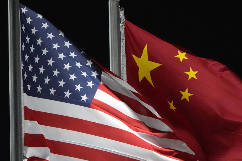 FILE - The American and Chinese flags wave at Genting Snow Park ahead of the 2022 Winter Olympics, Feb. 2, 2022, in Zhangjiakou, China. Secretary of State Antony Blinken has postponed  a planned high-stakes weekend diplomatic trip to China as the Biden administration weighs a broader response to the discovery of a high-altitude Chinese balloon flying over sensitive sites in the western United States, a U.S. official said Friday.  (AP Photo/Kiichiro Sato, File)