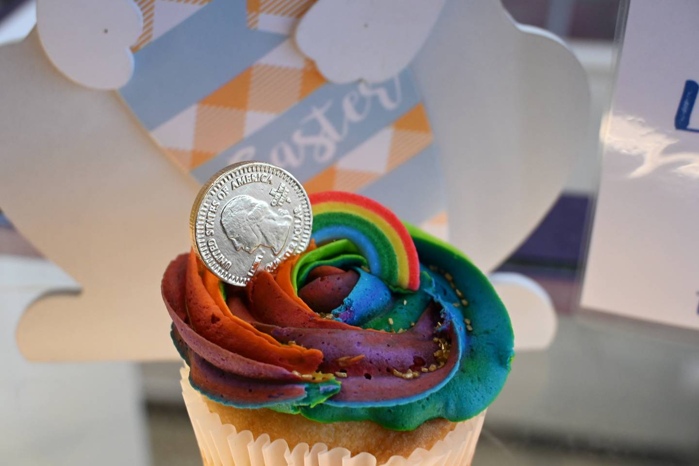 The Magical Rainbow cupcake. Made with chocolate or vanilla cake, frosted with colored vanilla buttercream and topped with a chocolate coin.