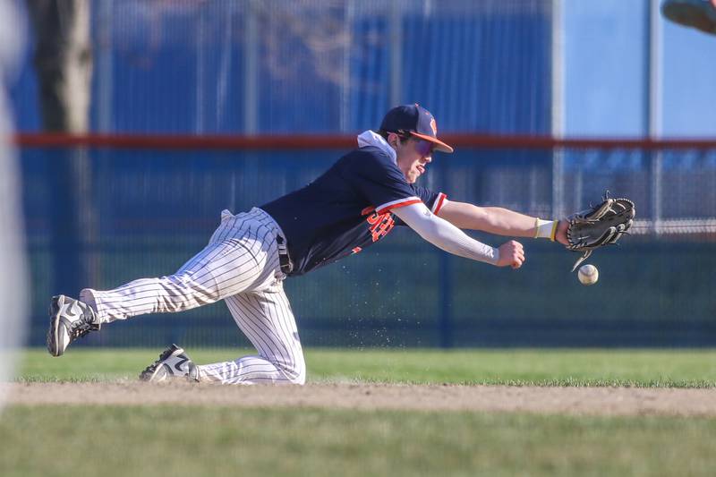 Oswego's Quinn Stanley (12) dives for a ground ball during baseball game between Plainfield South at Oswego on Monday, April 14, 2025 in Oswego.