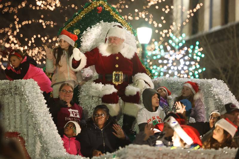 Santa waves to the crowds at the Light Up the Holidays Festival and Parade in downtown Joliet.