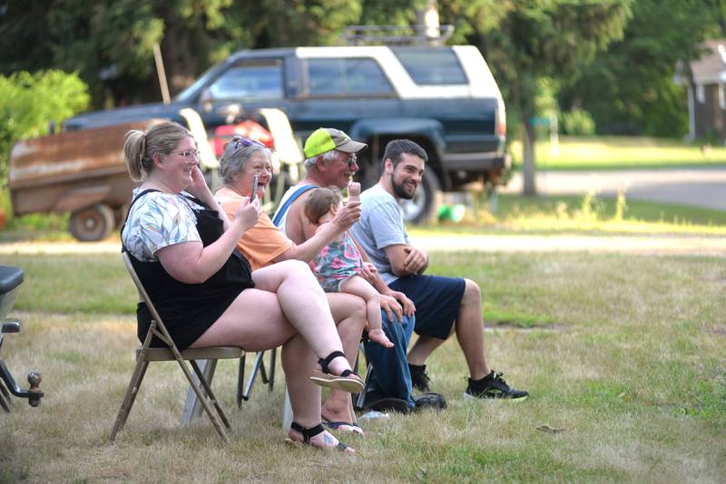 Grand Detour residents watch as the 7th Annual Grand Detour Golf Cart Parade passes by their home on Sunday, July 6.