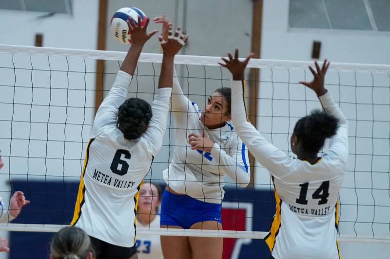 St. Charles North's Sidney Wright (22) goes up for a kill attempt against Metea Valley's Addison Torain (6) and Cheliyah Mattox (14) during a Class 4A West Aurora Sectional semifinal volleyball match at West Aurora High School on Tuesday, Nov. 5, 2024.