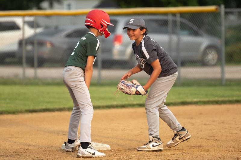 Hatzer & Sons baserunner Patrick Luckey (2) and Winterrowd Funeral middle infielder Jaxon Eplin share a laugh during the Streator Little League Major Division city championship game Wednesday, June 25, 2025, at Southside Park in Streator.
