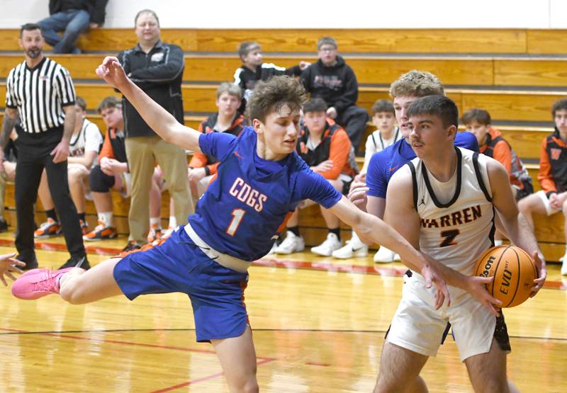 Genoa-Kingston's Kash Sunderlage (1) reaches for the ball as Warren's Nik Brinkmeier (2) protects it on Saturday, Dec. 13, 2025 at the 64th Annual Forreston Holiday Basketball Tournament held at Forreston High School.