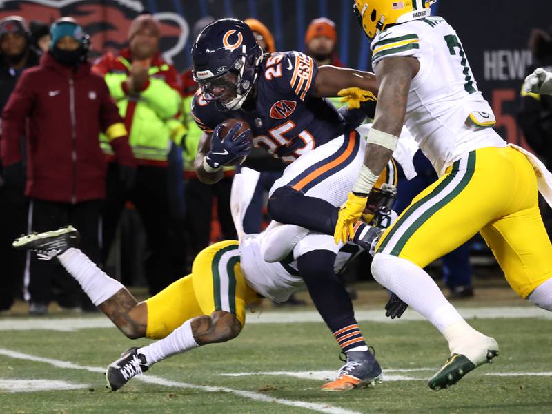 Chicago Bears running back Kyle Monangai goes between two Green Bay Packers defenders Saturday, December 20, 2025, during their game at Soldier Field in Chicago.