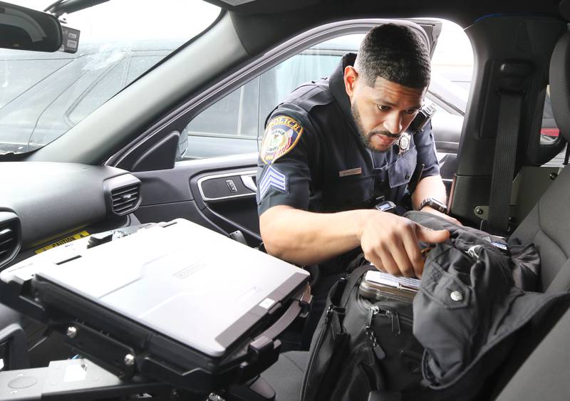 DeKalb Police Sgt. Raynaldo Hernandez puts his gear in his squad car as he prepares to start his shift Thursday, April 11, 2024, behind the DeKalb Police Department.