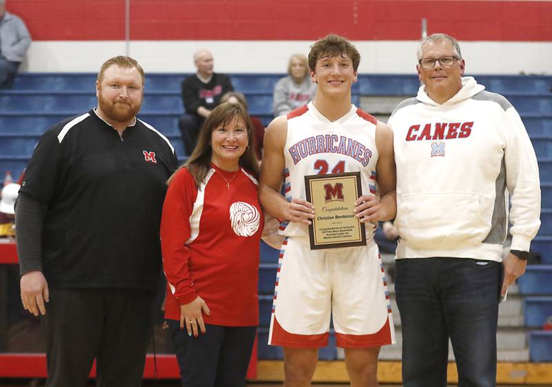Marian Central’s Christian Bentancur with his father, Patrick, mother, Elizabeth, and  Marian Central Athletic Director Cody O'Neill as he is honored with becoming Marian Central’s leading score and the only Illinois athlete to score 2,000, points and have over 200 receptions in football at halftime of a basketball game against Marengo on Tuesday, Feb.13, 2024, at Marian Central High School.