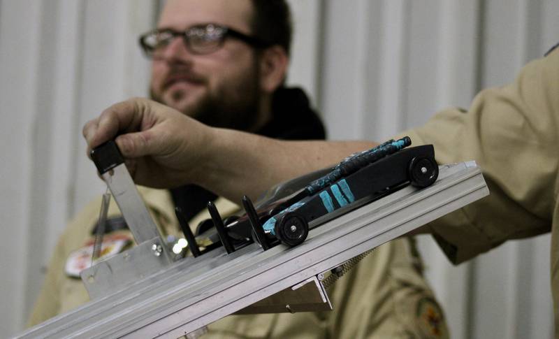 The starter pulls the lever sending three pinewood derby cars down the track at the Cub Scout Pack 85 Derby at Bethel Evangelical Congregational Church in Dixon on Saturday, Feb. 11, 2023.