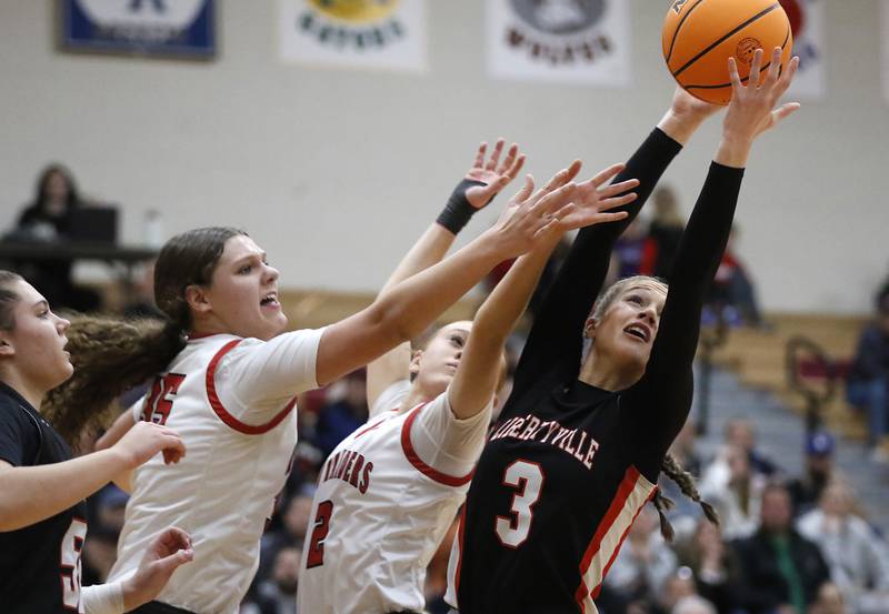 Huntley's Paula Strzelecki (left) and Avery Seuss (center) battle Libertyville's Lily Fisher for a rebound during an IHSA Class 4A Huntley Sectional Championship girls basketball game on Thursday, Feb. 27, 2025, at Huntley High School.